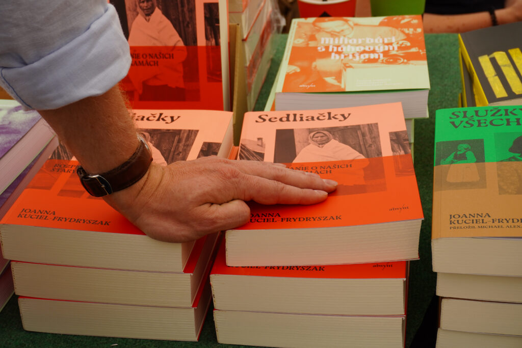 Ręka opiera się na stosie książek, widać okładkę książki Sedliacky 